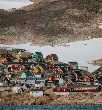 scoresby sund na groenlândia com casas coloridas entre neve e montanhas durante o dia ilustrando post seguro viagem groenlândia