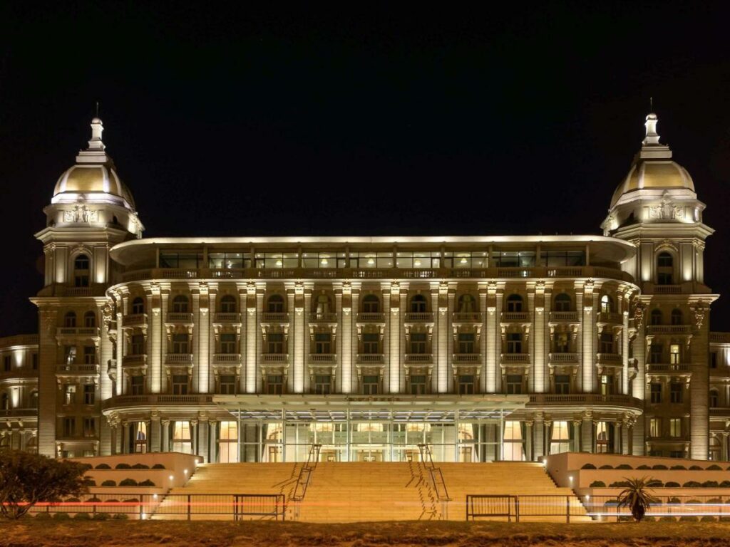 Fachada do Sofitel Montevideo Casino Carrasco & Spa, parecido com um museu, com uma escadaria na frente, muitas janelas e sacadas, para representar hotéis em Montevidéu