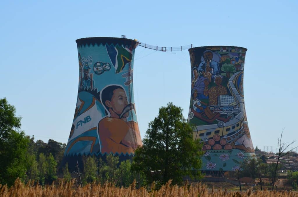 Antigas torres de carvão pintadas por artistas da região para ilustrar o post seuro viagem Johanesburgo. No centro delas há um espaço para bungee jump. - Foto: Michael Schofield via Unsplash