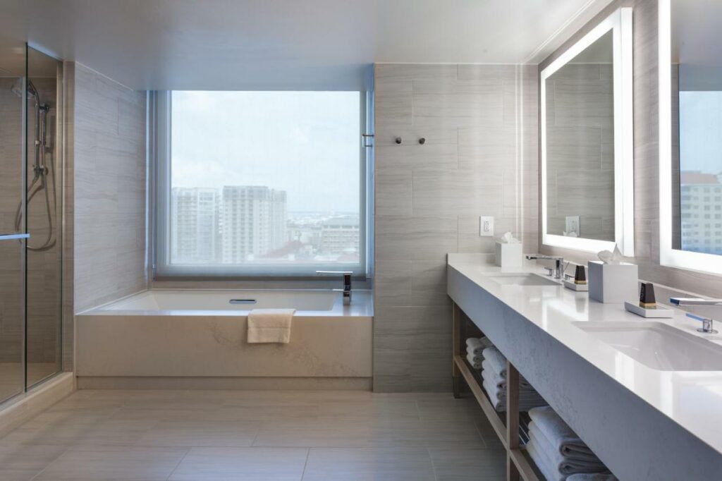 Banheiro amplo com uma banheira com uma ampla janela ao lado dando vista para a cidade no Tampa Marriott Water Street