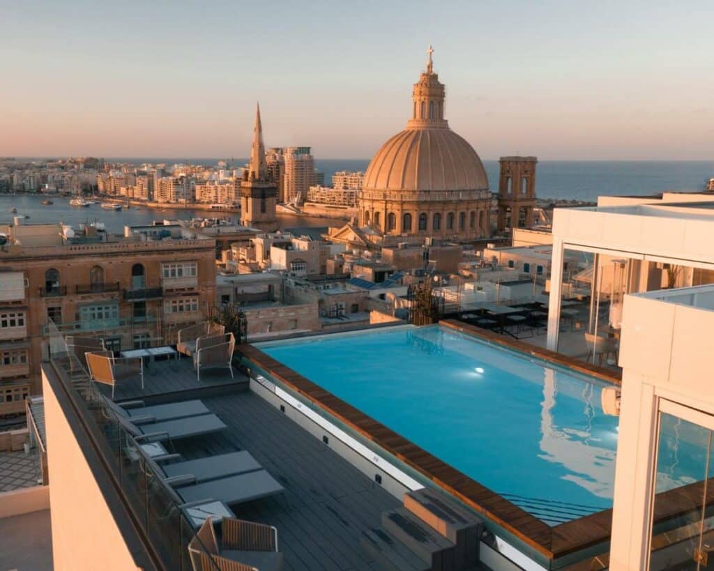 Piscina do The Embassy Valletta Hotel com vista para prédios e a igreja histórica da cidade