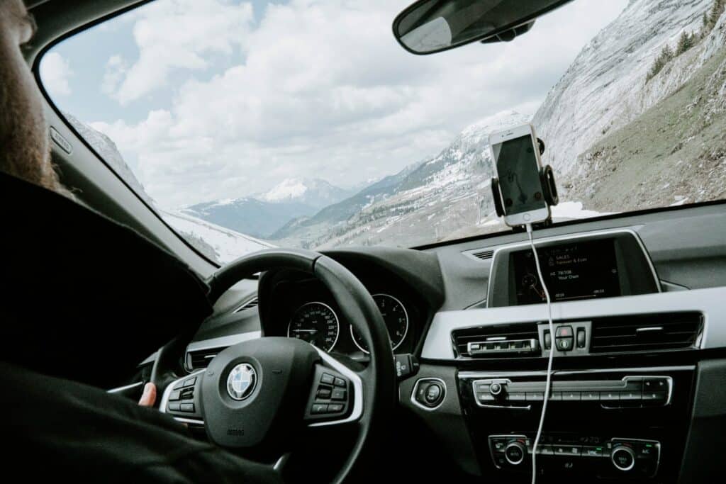 Exemplo de carro disponível para alugar pela Sixt - uma BMW, com painel multimídia e suporte para celular no para-brisa