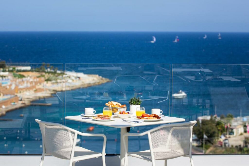 Varanda com vista para o mar no be.HOTEL com uma mesa e duas cadeiras
