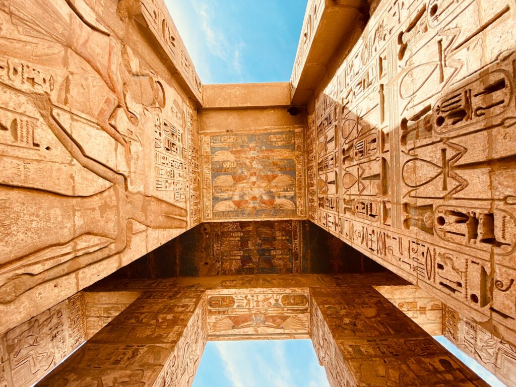 vista de baixo dos arcos na Necrópole de Tebas, no Egito, com diversos hieróglifos entalhados nas paredes de pedra