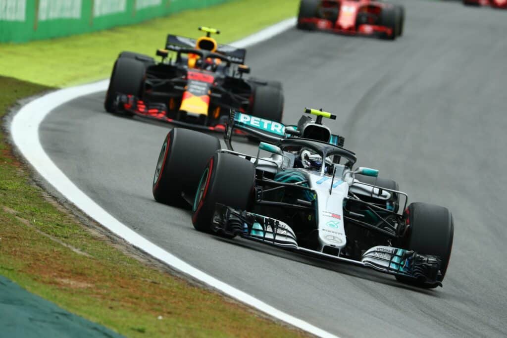 Dois carros de Fórmula 1 correndo em uma curva