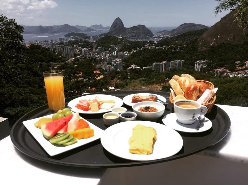 Café da manhã na Casa Marques, com a cidade do Rio de Janeiro e o Pão de Açúcar ao fundo.