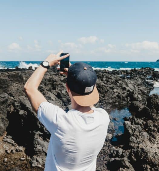 Homem tirando foto do mar em Maui. - Foto: Georgia de Lotz via Unsplash