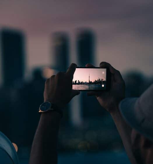 Homem tirando foto da Torre CN, em Toronto - Foto: Tandem X Visuals via Unsplash