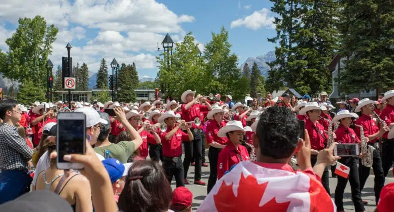 Pessoas tirando foto do desfile no Canadá durante o dia, ilustrando post chip celular Canadá