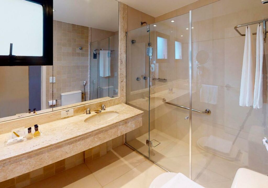 Banheiro adaptado do Estanplaza Nações Unidas com pia mais baixa e sem móvel embaixo, uma box  amplo com barras de apoio do lado de dentro, para representar hotéis em Lollapalooza