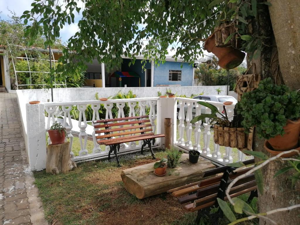 área externa com mesa e bancos de madeira em meio à natureza da Pousada TOP, uma das pousadas em Mairiporã