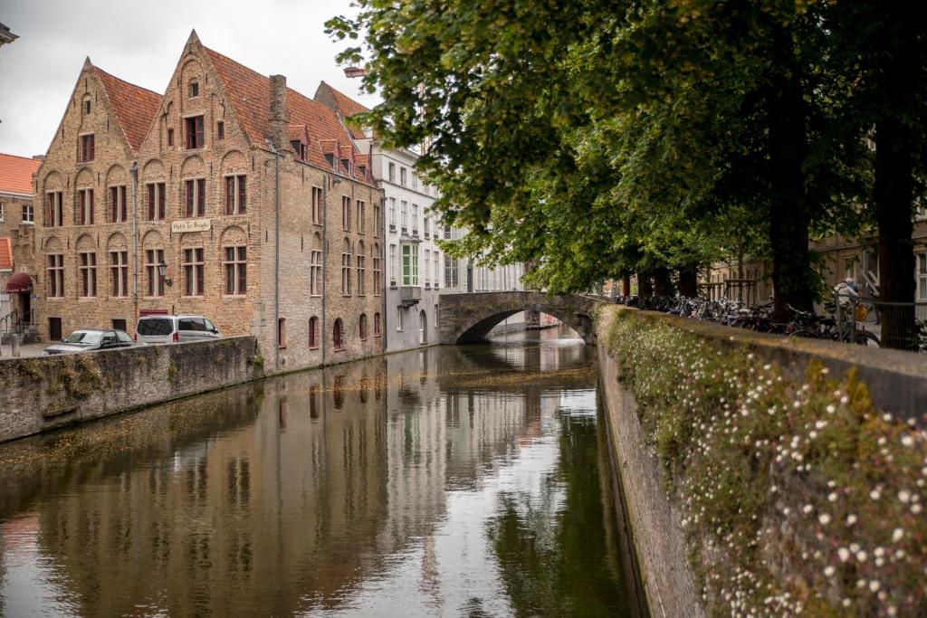 vista da fachada em estilo medieval do Hotel Ter Brughe, um dos hotéis em Bruges, com o rio ao lado