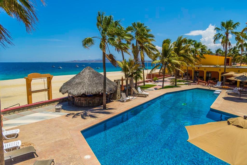 Piscina à beira-mar do Hotel Playa Del Sol com cadeiras a borda e céu claro sem nuvens.