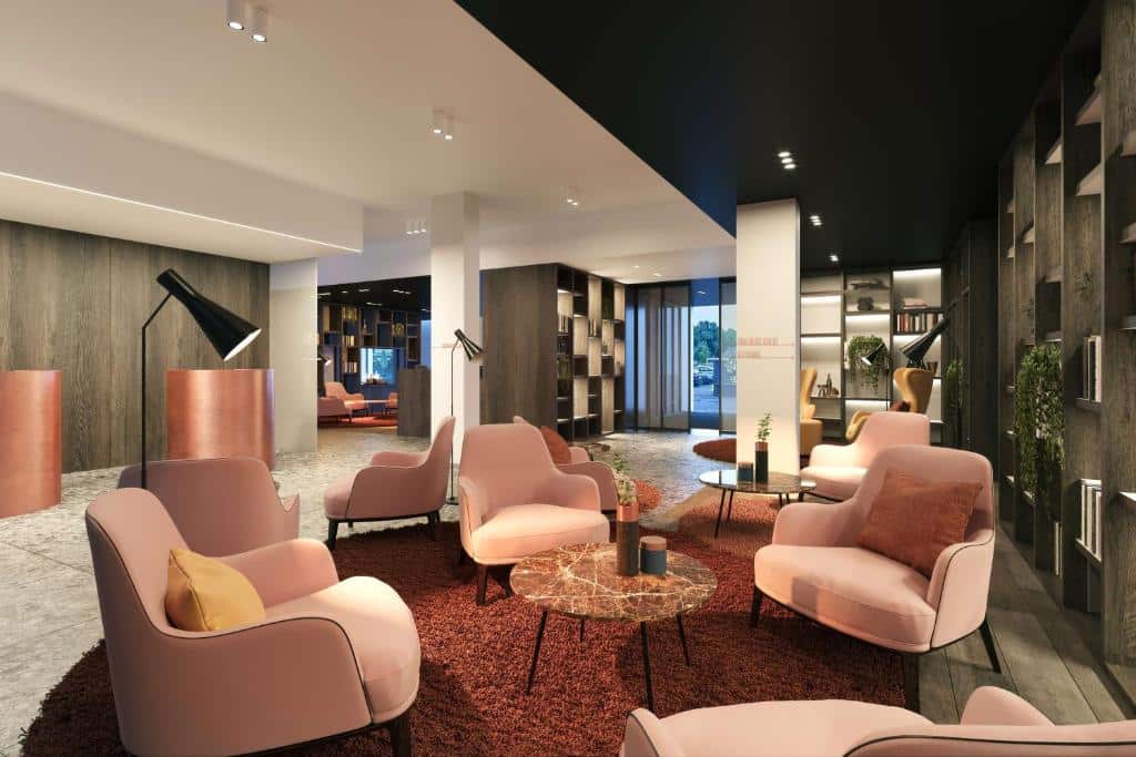 lounge do Radisson Blu Hotel, Bruges, um dos hotéis em Bruges, com diversas poltronas rosas e mesinhas de vidro decoradas com a recepção de fundo e decoração moderna