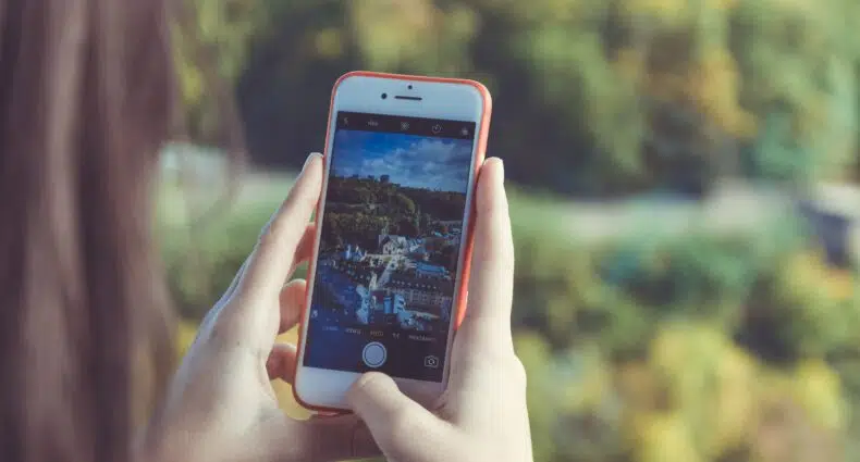 Celular na mão com a câmera aberta para tirar foto. Representa chip celular Luxemburgo