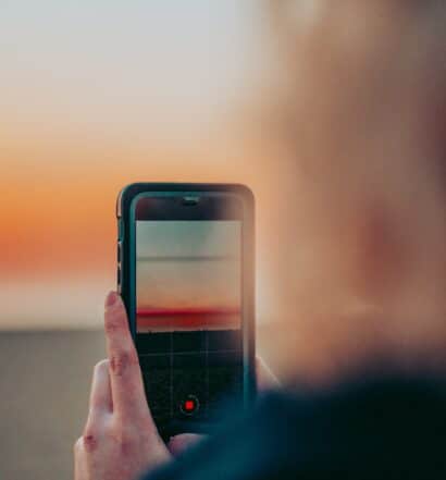 Celular na mão para tirar foto da praia de Venice, Los Angeles - Representa chip de celular Los Angeles