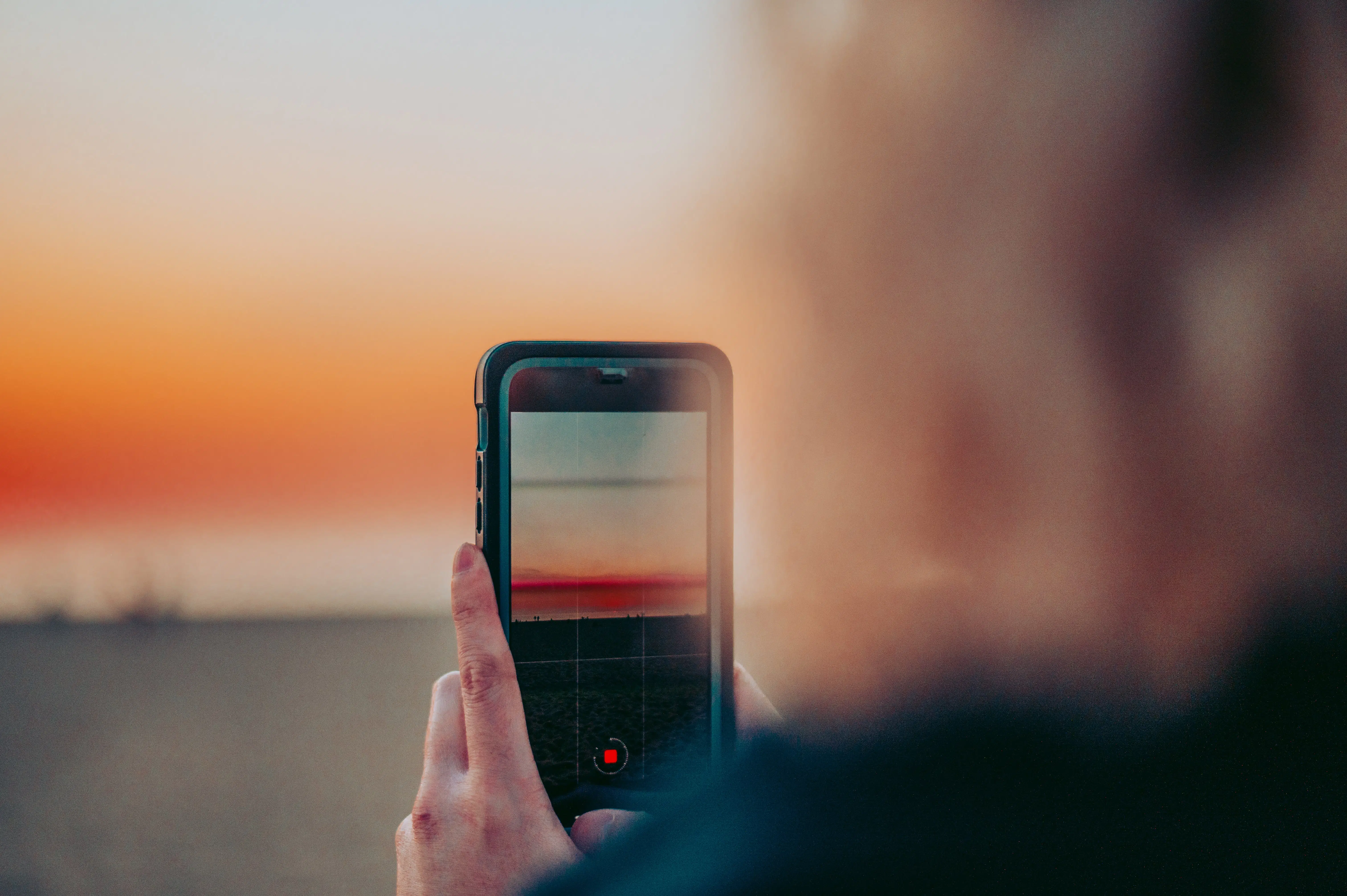 Celular na mão para tirar foto da praia de Venice, Los Angeles - Representa chip de celular Los Angeles