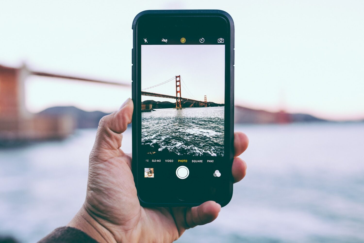Pessoa tirando foto da Golden Gate Bridge - Foto: Edgar Chaparro via Unsplash