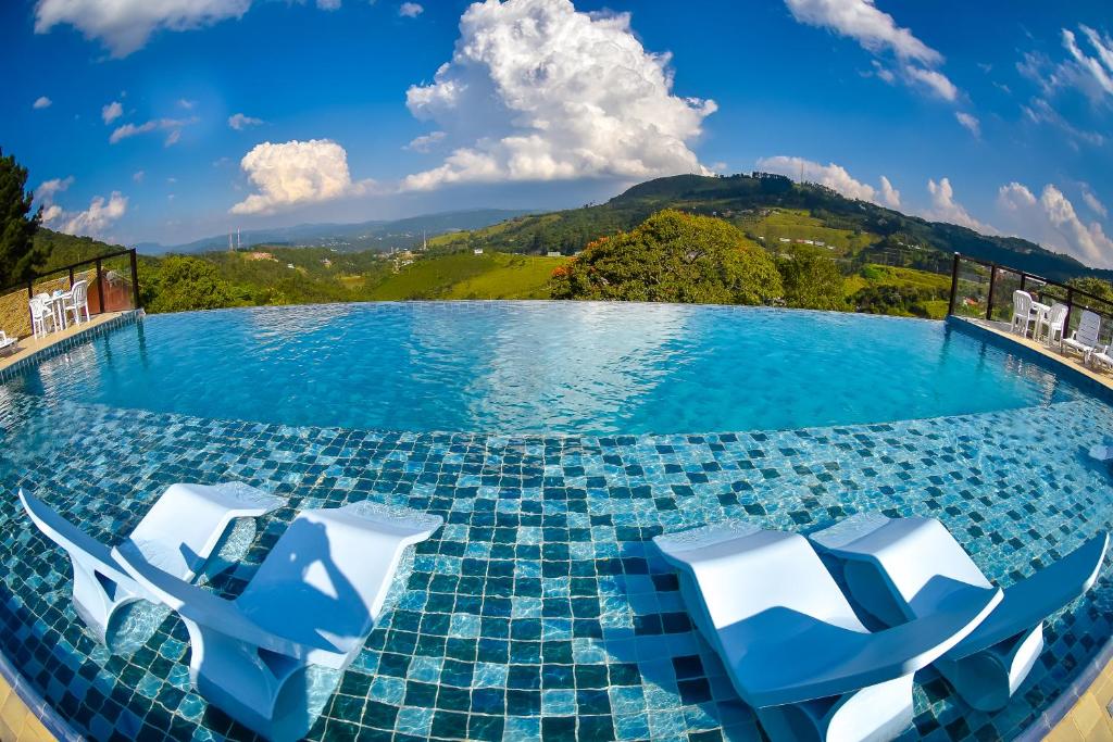 piscina com borda infinita e vista das monstanhas com espreguiçadeiras no Hotel Refúgio Vista Serrana, um dos hotéis em Mairiporã