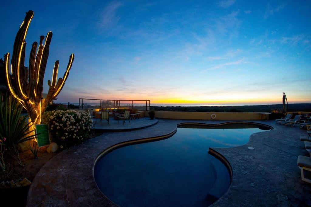 Piscina do Hotel Boutique Vista La Ribera no pôr-do-sol com cadeiras ao redor da piscina.