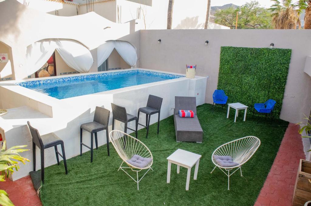 Vista da piscina do Donjuan By Melida Hotel  com área de lazer, o local conta com várias cadeiras colocadas na grama. Representa hotéis em Los Cabos.