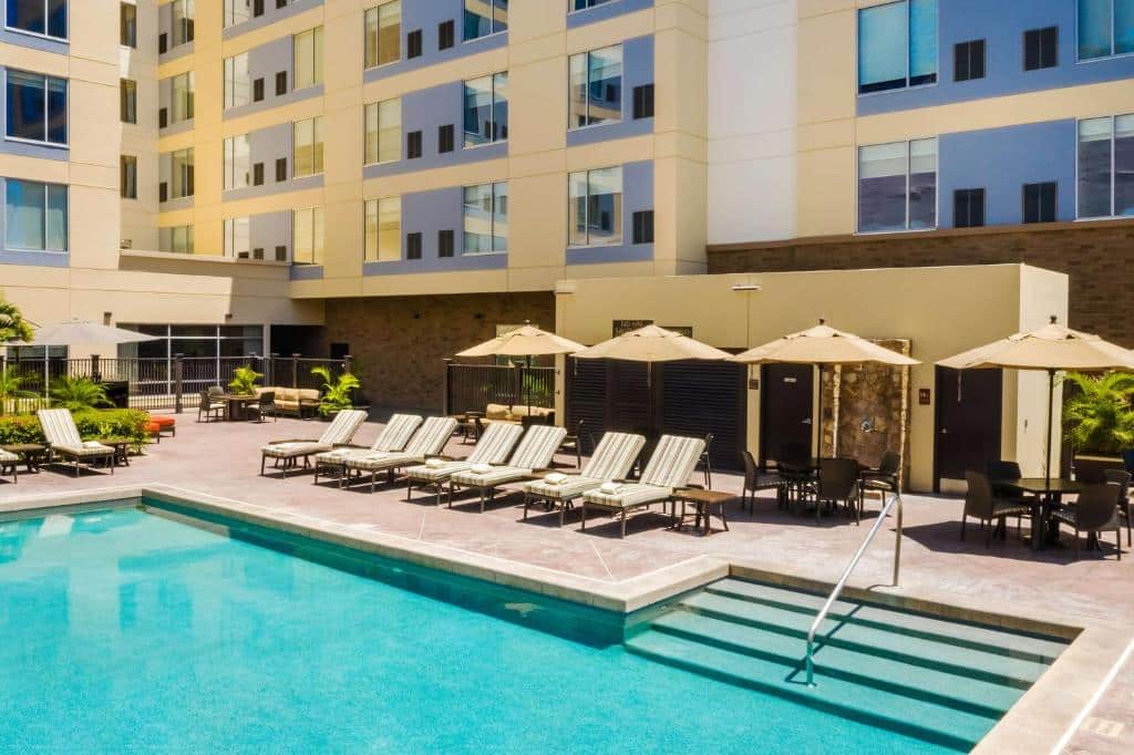 Vista da piscina do Hyatt Place Los Cabos  com cadeiras e guarda-sóis em volta. Representa hotéis em Los Cabos.