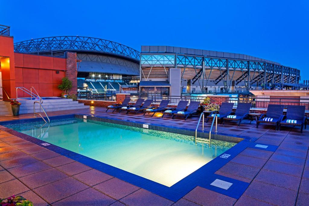 Piscina iluminada no anoitecer do  Silver Cloud Hotel – Seattle Stadium com cadeiras em volta, em hotéis em Seattle.