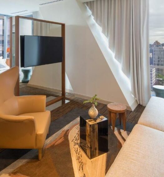 Vista do quarto do Lotte Hotel Seattle, com cama de casal com sala de estar e janelas panoramicas. Representa hotéis em Seattle