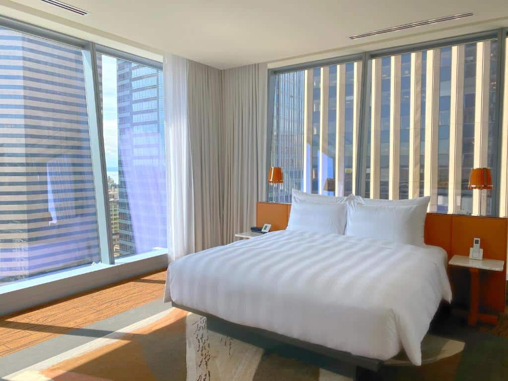 Quarto com cama de casal e janelas panoramicas do Lotte Hotel Seattle.