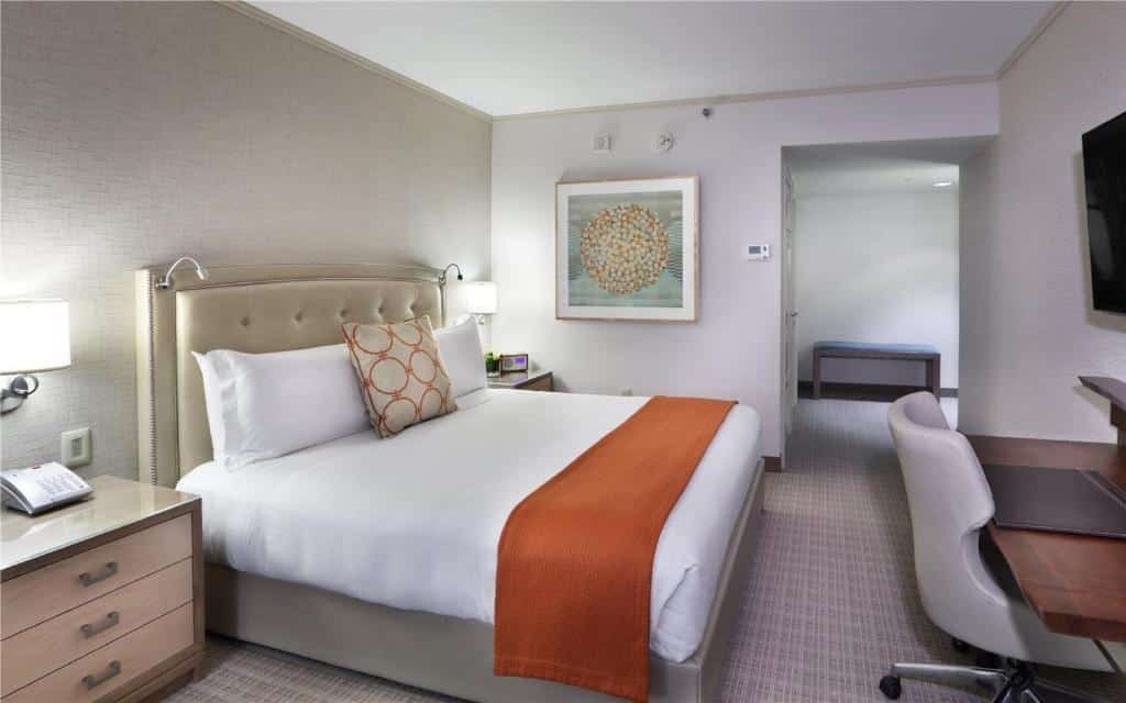 Quarto do Seaport Hotel® Boston com cama de casal ampla, mesa de trabalho e TV.