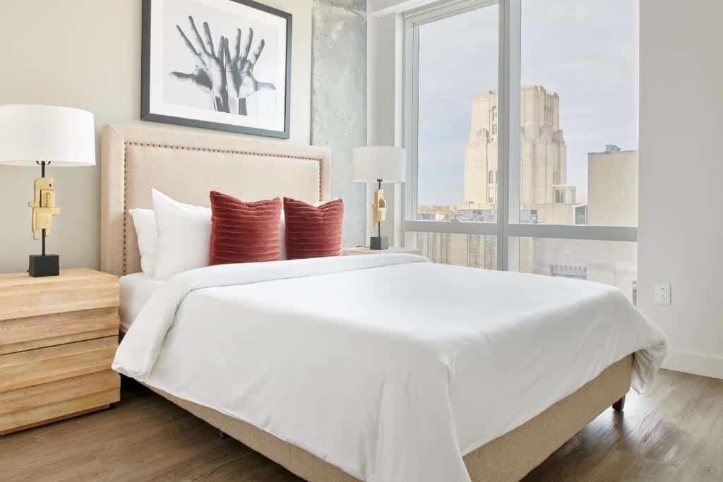 Quarto Sonder at Pierce Boston com cama de casal e janela ampla e duas cômodas ao lado.