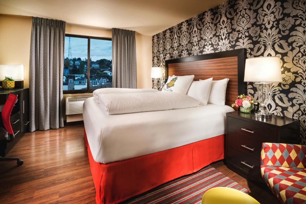 Quarto com cama de casal duas comodas ao lado com luminárias, janela ampla, mesa de trabalho e cadeira no Staypineapple, The Maxwell Hotel, Seattle Center Seattle.