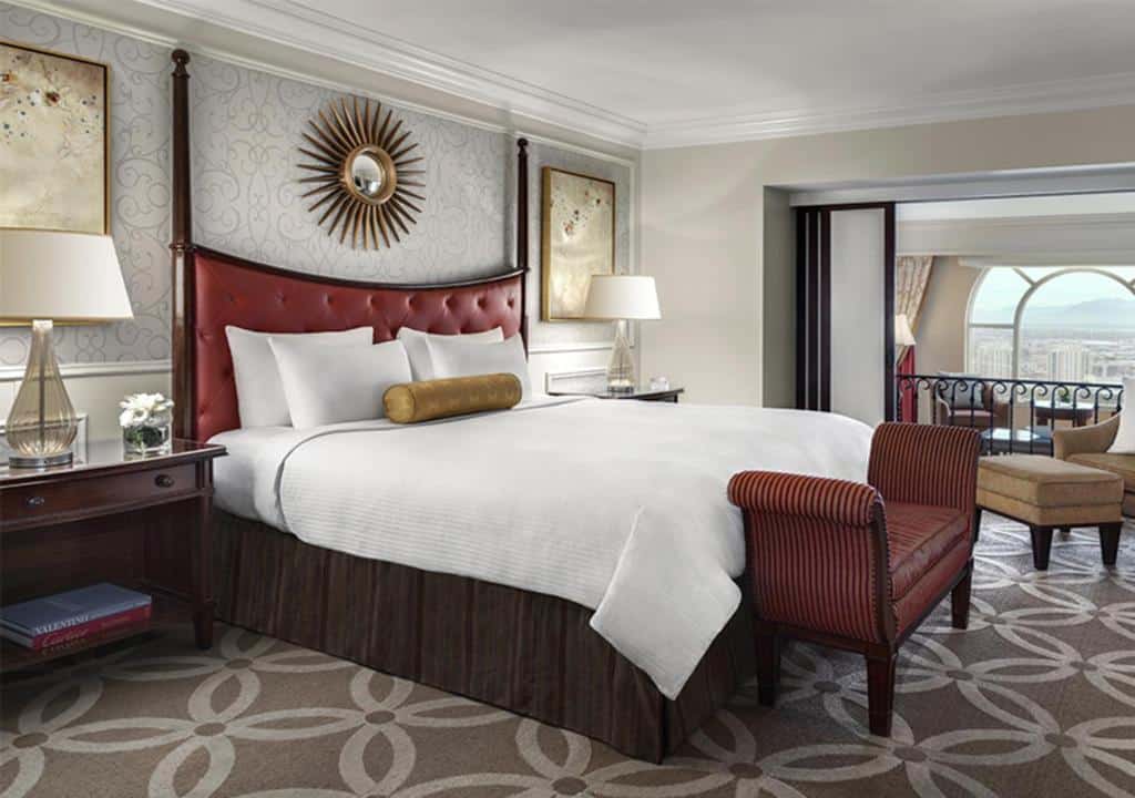 Quarto no The Venetian® Resort Las Vegas do lado esquerdo é uma cama de casal com duas mesinhas de cabeceira com abajures, na parede atrás da cama tem quadros, há um carpete cinza com desenhos brancos
