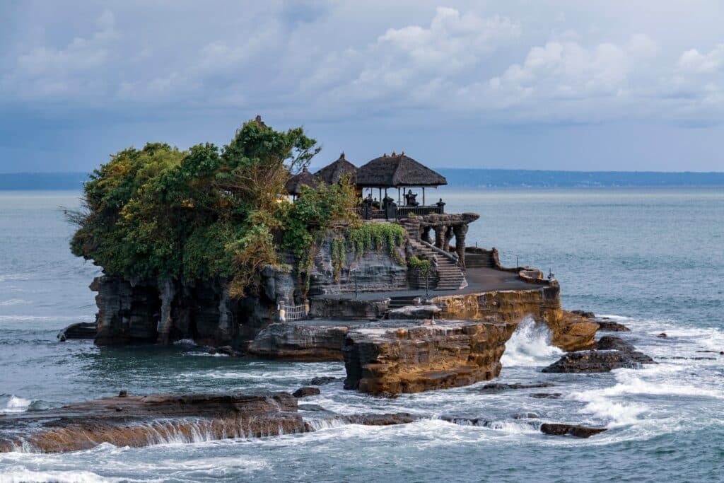 Tanah Lot uma formação de rochas sobre o mar, ilustrando post seguro viagem Bali.