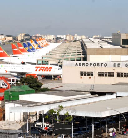 Parte interna do aeroporto com muitos aviões um do lado do outro