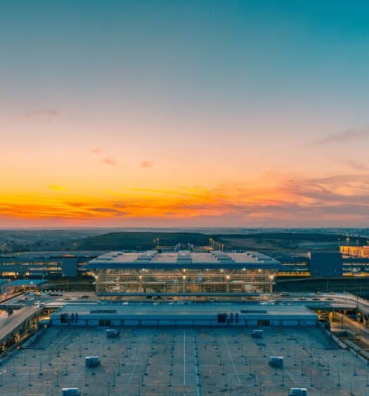 Imagem aérea do Aeroporto de Viracopos com um entardecer ao fundo