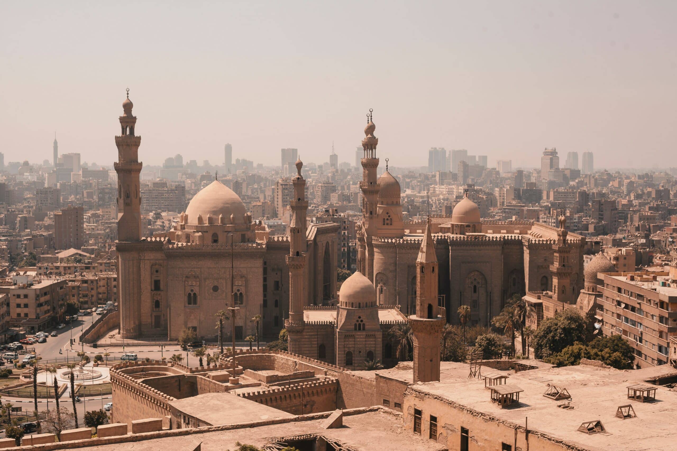 A Mesquita de Rifai e Sultan Hassan em meio a cidade do Cairo com o típico céu arenoso da capital do Egito. Representa chip celular Cairo