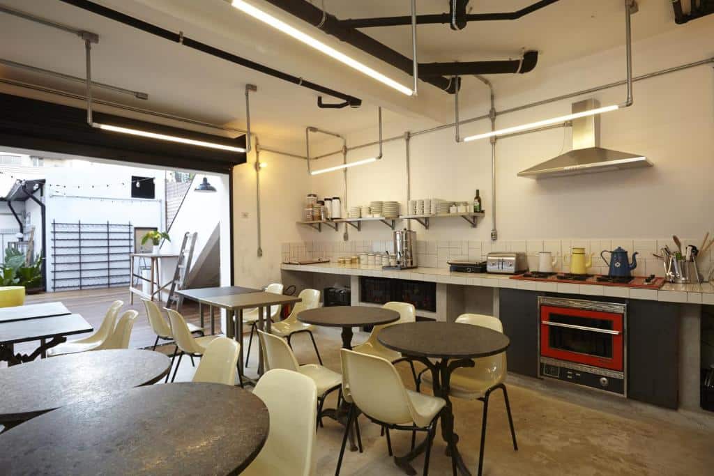 Cozinha compartilhada do Guest Urban Hotel Design Pinheiros com mesas e cadeiras ao dispor também
