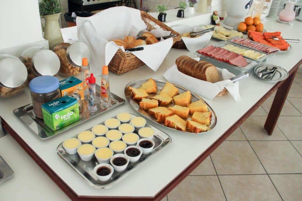Mesa de café da manhã do Hotel Cisne com pães, frios e bolos a disposição dos hóspedes