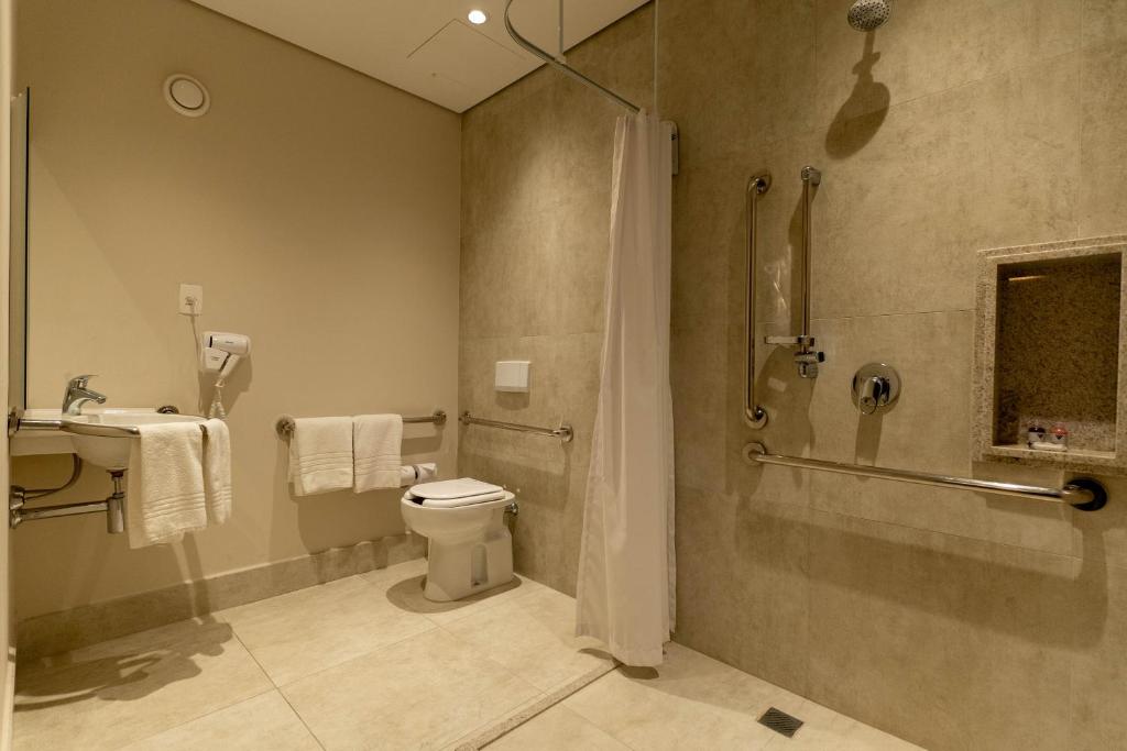 Banheiro adaptado do Hotel Contemporâneo - Royal Palm Hotels & Resorts com barras de apoio no box, próximo da privada e pia