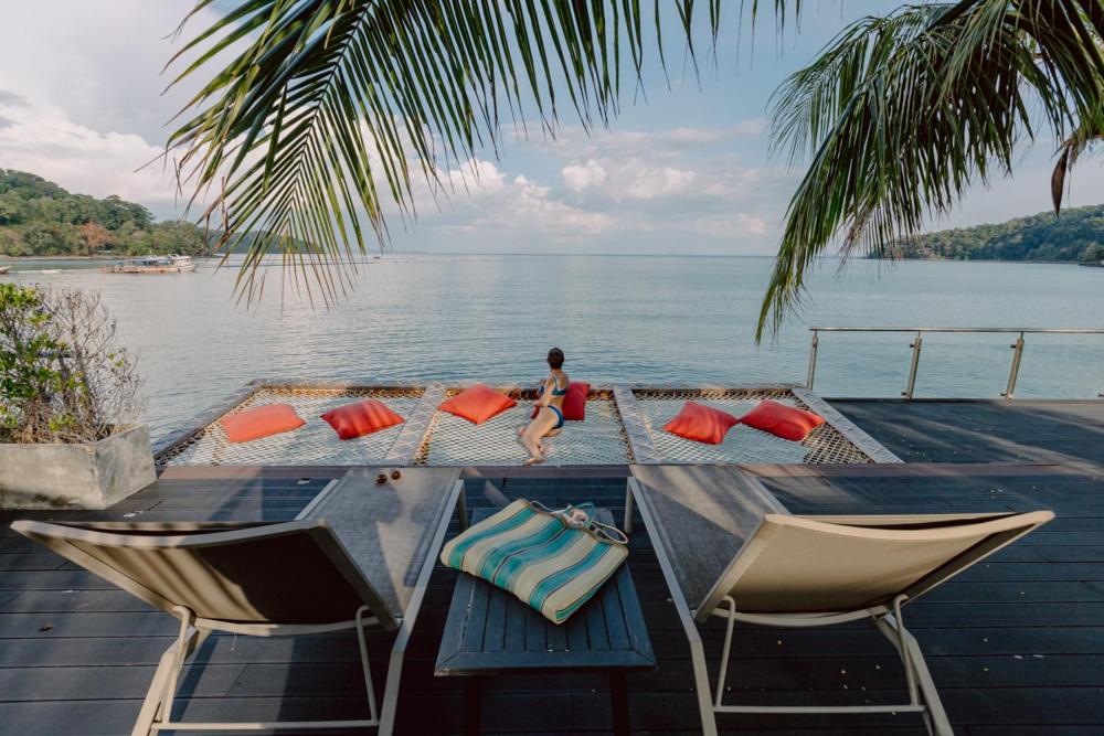 Hotel Tide Phuket Beach front, cadeiras de praia localizadas de frente para o mar com uma pessoa ao centro.
