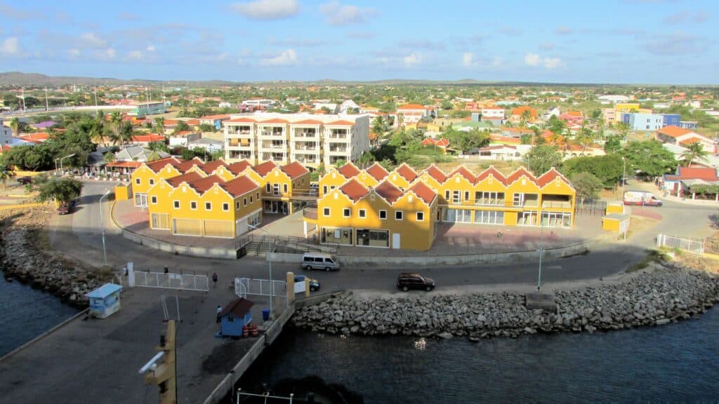 vista da capital Kralendijk, para ilustrar o post de chip celular Bonaire, com construções clássicas holandesas coloridas, principalmente em amarelo em uma baía com ponte e detalhes em pedra