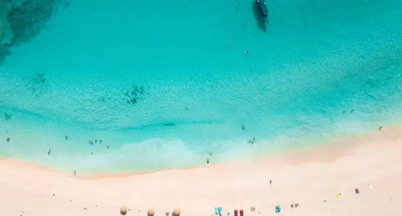 Vista de cima da Ilha St Martin com mar azul claro e areia branca. Representa chip celular St Martin