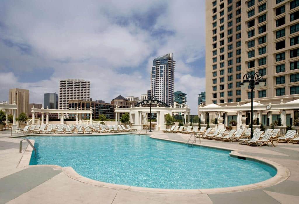 Piscina do Manchester Grand Hyatt San Diego com cadeiras em volta da piscina em dia ensolarado. Representa hotéis em San Diego
