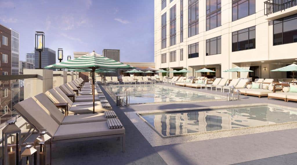 Vista da piscina do Pendry San Diego com cadeiras em volta na cobertura do hotel com dia de sol. Representa hotéis em San Diego