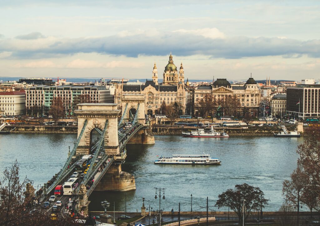 Ponte acima de rio com prédios e o Parlamento para ilustrar o post sobre chip de celular para Budapeste. - Foto: Anna Hunko via Unsplash
