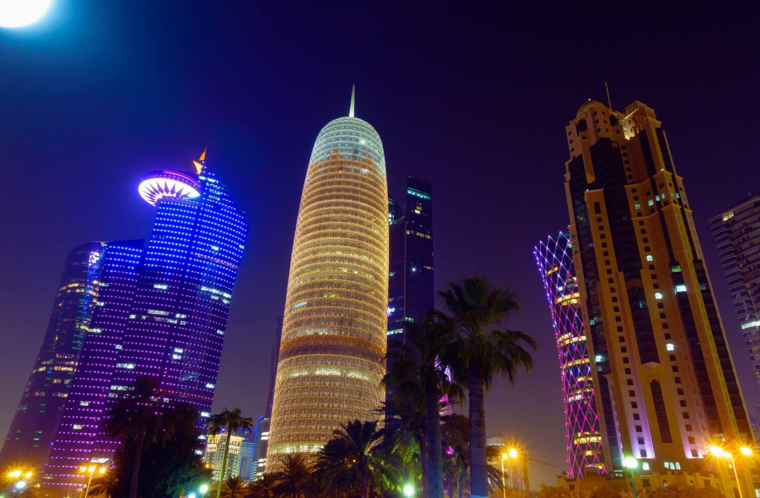 Arranha-céus iluminados à noite para ilustrar o post sobre chip de celular para o Qatar. - Foto: Mike Swigunski via Unsplash
