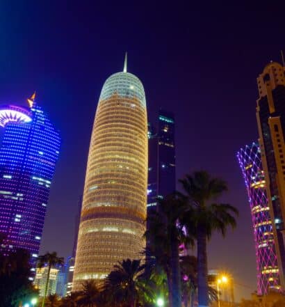 Arranha-céus iluminados à noite para ilustrar o post sobre chip de celular para o Qatar. - Foto: Mike Swigunski via Unsplash