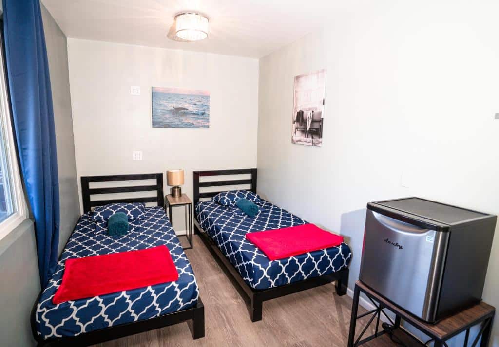 Quarto do California Dreams Hostel - Ocean Beach com duas cama de solteiro e um frigobar ao lado esquerdo.