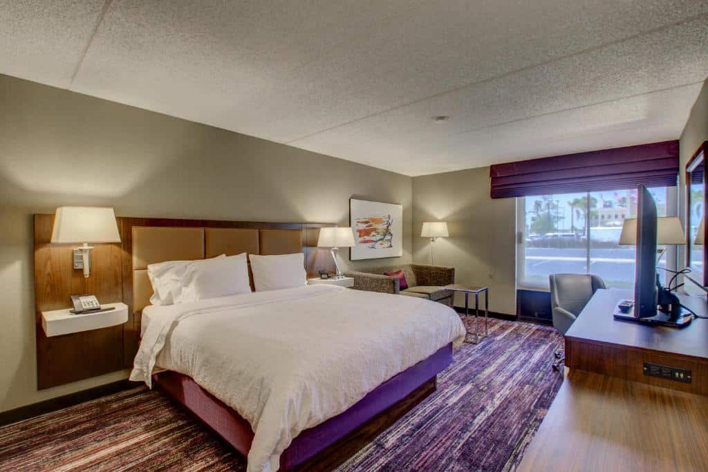 Quarto do Hampton Inn by Hilton San Diego – Kearny Mesa com cama de casal, duas cômodas ao lado com luminária, TV a frente em cima de uma cômoda.